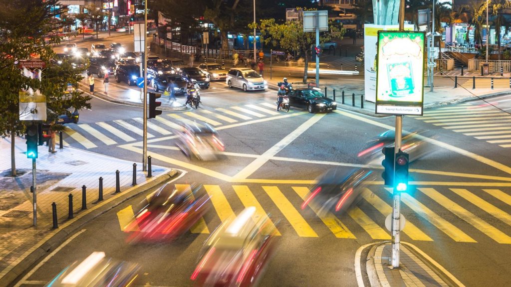 Cars crossing a busy intersectoin with ITS safety technologies and signals